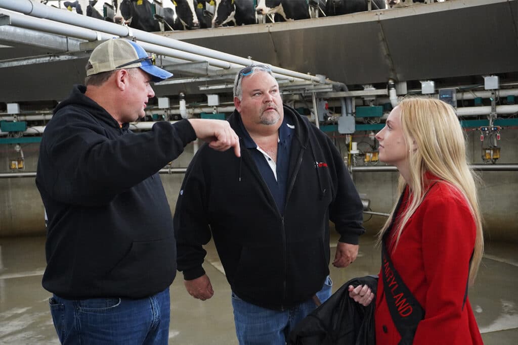 Steve Abel discussing the rotary milking machine with Dean Birschbach and the current Alice in Dairyland, Ashley Hagenow.