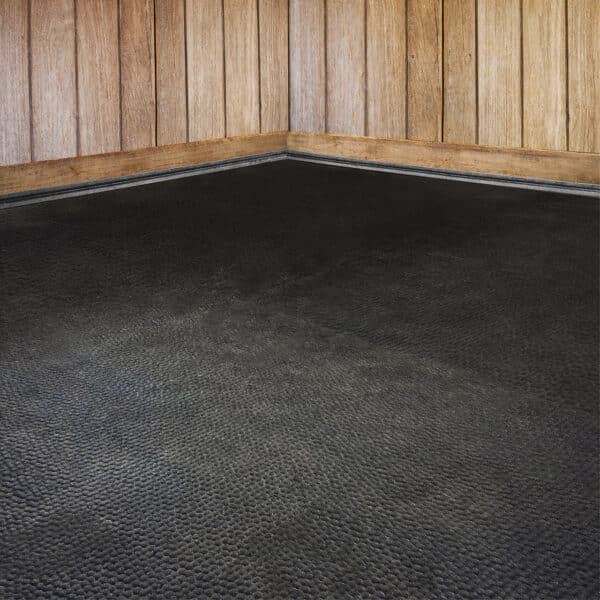 Extra soft stall mats installed in a stable stall for horses.