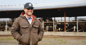 Postma Dairy, Modesto, CA. Picture of Jon Postma in front of cow barn.