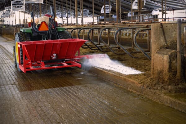 Agromatic AG Lime Master Pro spreading lime over manure bedding in freestall barn.