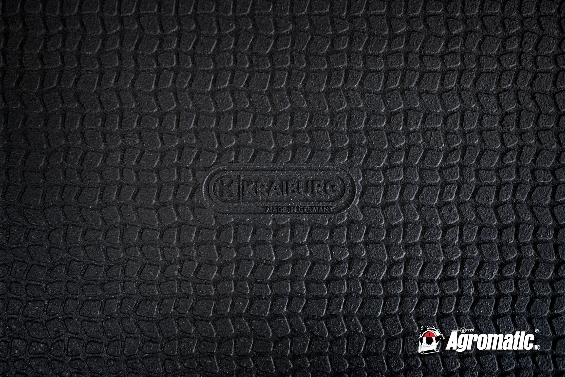 The pebbled surface of KRAIBURG's interlocking cow mats with the KRAIBURG logo stamped on. This is the surface used for both Cirrus and Kura mats.