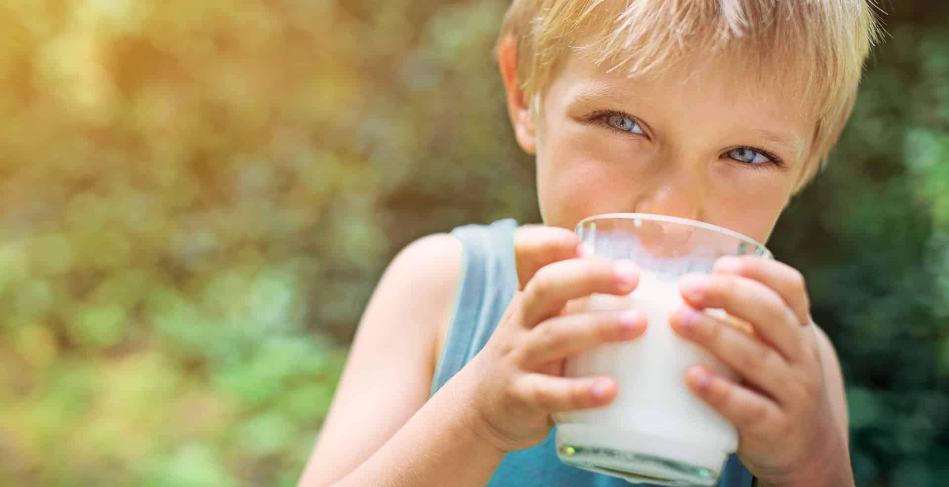 June Dairy Month picture of kid drinking milk in a glass outside.